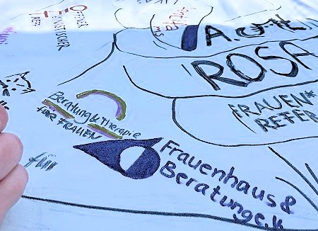 Bemaltes Transparent mit dem Schriftzu des Frauenhauses und der Beratungsstelle